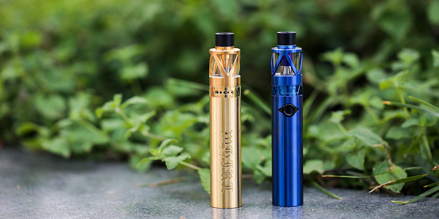 gold and blue vape devices with green grass in the background